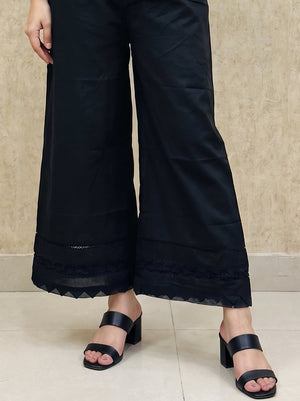 triangle cutwork border and lace inserts on Khaadi black trousers.