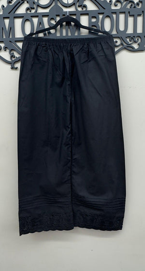 floral embroidered scalloped hem and pin-tuck pleats on black cotton trousers.