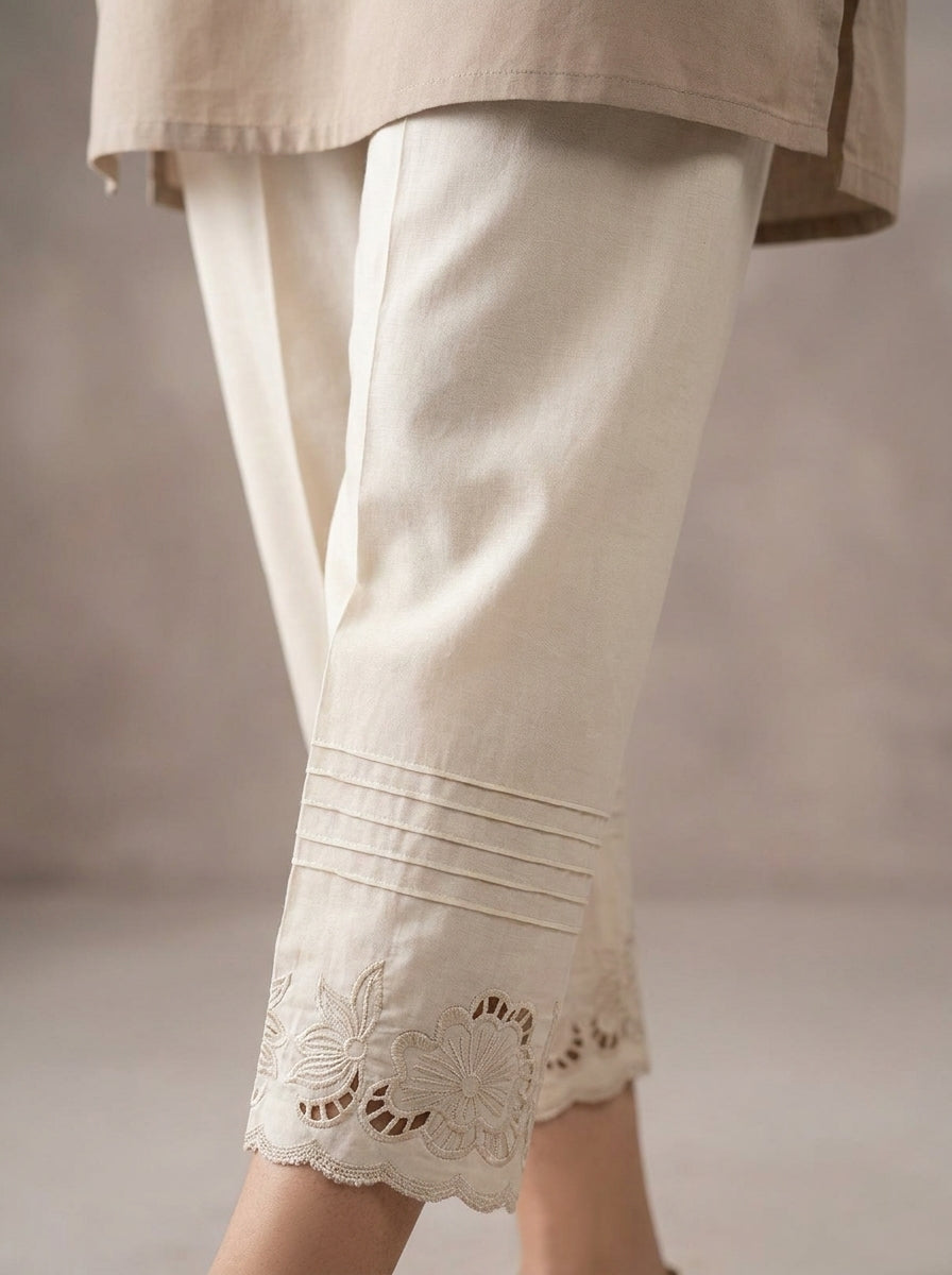 Off-white cotton straight trouser featuring floral cutwork embroidery along the bottom hem.