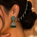 Oxidized silver jhumka earrings with emerald green stones and decorative sahara chain.