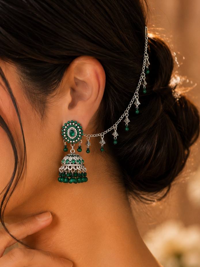 Oxidized silver jhumka earrings with emerald green stones and decorative sahara chain.