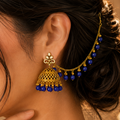 Traditional gold jhumka earrings with royal blue beads and matching sahara chain for bridal and festive wear.